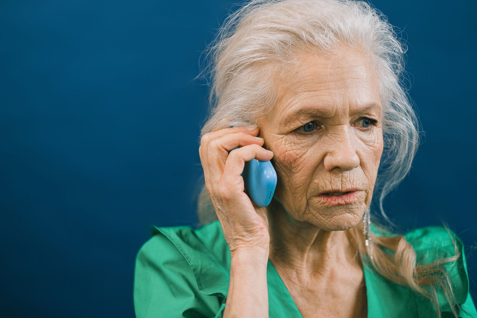 Mujer mayor preocupada durante una llamada telefónica sospechosa