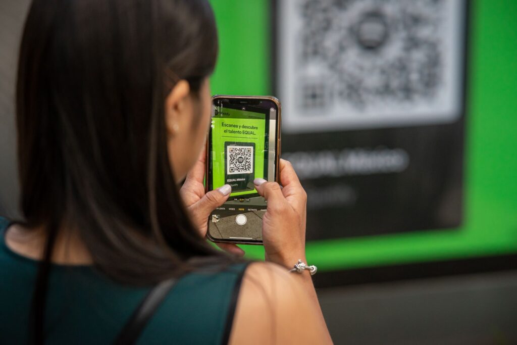 Persona escaneando un código QR con el móvil, como se hace en un cajero de bitcoin